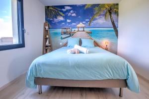a bedroom with a bed with a painting of a beach at Sunset villa in Trélissac +38 photos