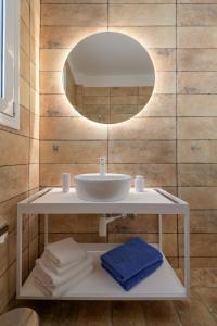 a bathroom with a sink and a mirror at Asteria Pearl Villa 1 with Jacuzzi in Tigaki