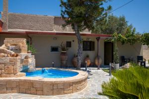 a patio with a hot tub in front of a house at Cactus Aegina Apartments in Aegina Town