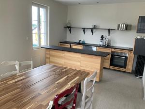 eine Küche mit einem Holztisch und einer Arbeitsplatte in der Unterkunft Appartement Hôtel de la Gare 3 chambres in Château-du-Loir