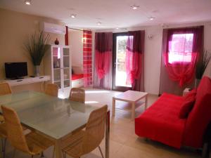 a living room with a table and a red couch at Residence Borgo Punta Villa in La Maddalena