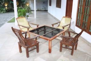 a wooden table with two chairs and a glass top at Dream Villa - Weligama in Weligama