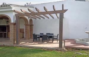 a wooden pergola with a table and chairs on a patio at Stunning Home In Casarabonela in Casarabonela