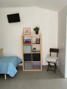a bedroom with a bed and a book shelf at Casa Praia do Sul in Ericeira