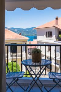 a table on a balcony with a plant on it at GRAND SUITE by F & G in Kastoria