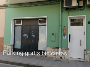 a green building with a white door and a window at lo flamenc @Amposta in Amposta +38 photos