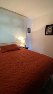 une chambre avec un lit avec une couverture rouge dans l'établissement Petápolis 2 - Apartamento en el centro de la ciudad - Zona 12 de la Ciudad de Guatemala, à Guatemala 11 autres photos