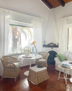 a living room with a table and chairs and a window at Villa des Arts - Taormina in Taormina