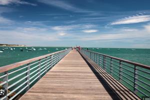un paseo marítimo de madera se extiende hacia el océano en Cozy 24 m studio near the sea, en La Tranche-sur-Mer