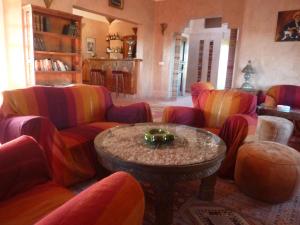 - un salon avec des chaises colorées et une table dans l'établissement Les Tourmalines, à Ouarzazate