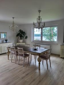 a dining room with a wooden table and chairs at Apartament nad jeziorem Zamkowym in Wałcz