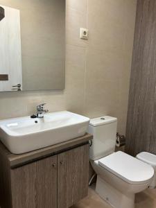 łazienka z białą umywalką i toaletą w obiekcie Apartamentos El Prau w mieście Ubiarco