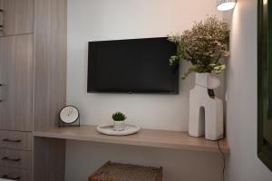 een woonkamer met een tv aan de muur bij Kythnos Seaside House Flampouria in Kithnos