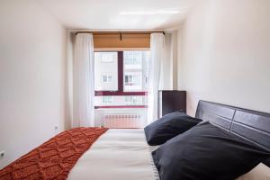 sypialnia z dużym łóżkiem i oknem w obiekcie Apartamento Lua w mieście Milladoiro