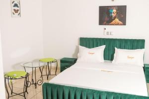 a bed with a green headboard in a room at Hotel Résidence Essiéniguet in Abidjan +63 photos