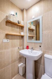 łazienka z umywalką, toaletą i lustrem w obiekcie Apartamento Lua w mieście Milladoiro