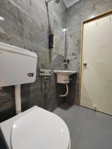 a bathroom with a white toilet and a sink at Hotel PRASANG in Surat +16 photos