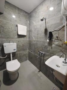 a bathroom with a toilet and a sink at Hotel PRASANG in Surat