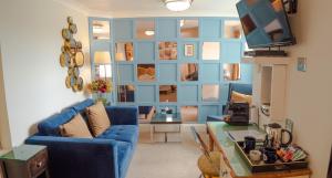 a living room with a blue wall and a blue couch at Riviera Lodge Hotel in Torquay