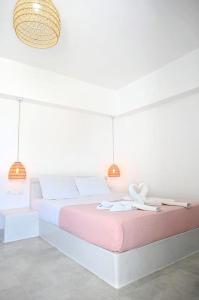a bedroom with a large bed with two lights at Cycladic Nest in Dryopida in Kithnos