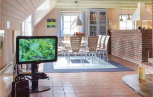 einen TV im Wohnzimmer mit einem Tisch und Stühlen in der Unterkunft Awesome Home In Ringkøbing With Kitchen in Klegod + 19 Fotos