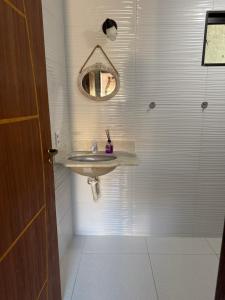 um banheiro com uma pia e um espelho em Loft praia do pontal, arraial do cabo Rj em Arraial do Cabo mais 5 fotografias
