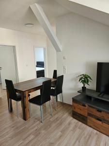 a dining room with a table and chairs and a television at Ferienwohnung 70qm Mörnsheim in Mörnsheim