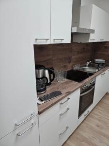 a kitchen with white cabinets and a stove top oven at Ferienwohnung 70qm Mörnsheim in Mörnsheim