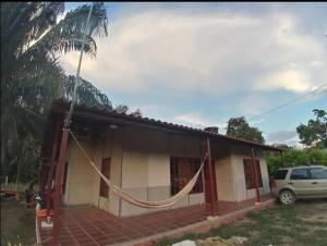a small house with a hammock in front of it at Casa vacacional en Carmen de Apicala con piscina in Carmen de Apicalá