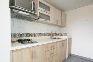 a kitchen with wooden cabinets and a sink and a microwave at Beautiful apt in Poblado-Tesoro Near Provenza! in Medellín +10 photos