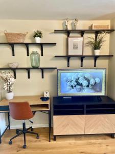 a room with a desk and a tv and shelves at 3 bed house near York centre with off road parking in York