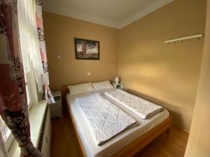 a small bedroom with a bed with white sheets at Villa Parkblick Wohnung 2 in Oberhof