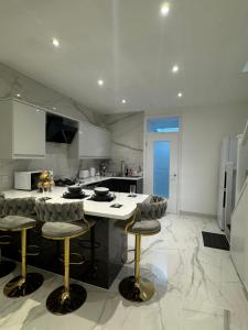 a kitchen with a large island with bar stools at The Opulence - 5 Star in Burnley