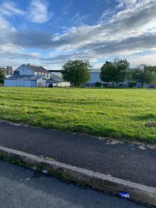 a field of green grass next to a road at The Opulence - 5 Star in Burnley