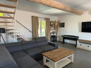 a living room with a couch and a piano at Belle maison piscine in Arles