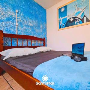 a bedroom with a bed with a laptop on it at SANTO MAR HOSTEL in Arraial do Cabo