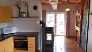 a kitchen with a black counter and a microwave at Ferienhaus Radlwiesn in Sankt Margarethen im Burgenland