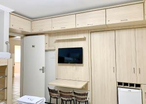 eine Küche mit Holzschränken und einem Tisch mit Stühlen in der Unterkunft diRoma Rio Quente 1km do Hot Park in Rio Quente