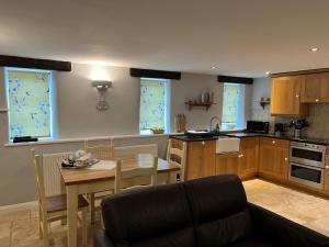 a kitchen with a table and a dining room at Bow Cottage in Paignton