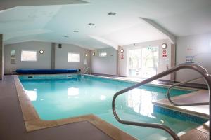 a large swimming pool with a staircase in a building at Bow Cottage in Paignton
