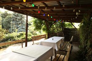 two tables and chairs under a pergola with lights at Biwak Bajlando in Wrocław