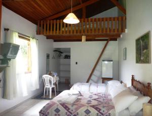 Un dormitorio con una cama y un televisor. en Pousada Passaredo, en Gonçalves 12 fotos más