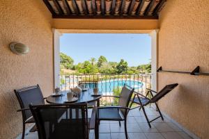 un patio avec une table et des chaises et une piscine dans l'établissement Résidence Les Parcs de Grimaud - maeva Home - Studio 4 personnes - Sélection MAE-4361, à Grimaud