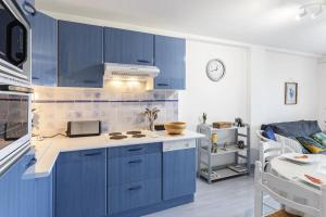 a kitchen with blue cabinets and a sink at Résidence La Commanderie - maeva Home - Appartement vue sur le port 2 pièces 4 personnes - Sélection - super Home MAE-7721 in Arzon