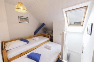 two twin beds in a small room with a window at Résidence La Commanderie - maeva Home - Appartement vue sur le port 2 pièces 4 personnes - Sélection - super Home MAE-7721 in Arzon +1 photo