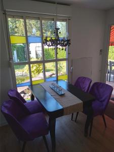 a dining room with a table and purple chairs at Fewo Rudow in Leuengarten +14 photos