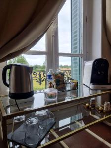 a kitchen counter with a coffee pot and a window at Mon coin secret in Sancoins