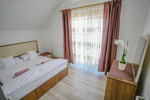 a bedroom with a bed and a large window at Eden House 188A in Târgu-Mureş