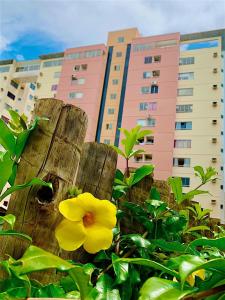 eine gelbe Blume auf einem Zaun vor einem Gebäude in der Unterkunft diRoma Rio Quente 1km do Hot Park in Rio Quente