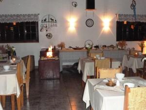 un restaurant avec des tables blanches et un chercheur de table blanc dans l'établissement Pousada Passaredo, à Gonçalves